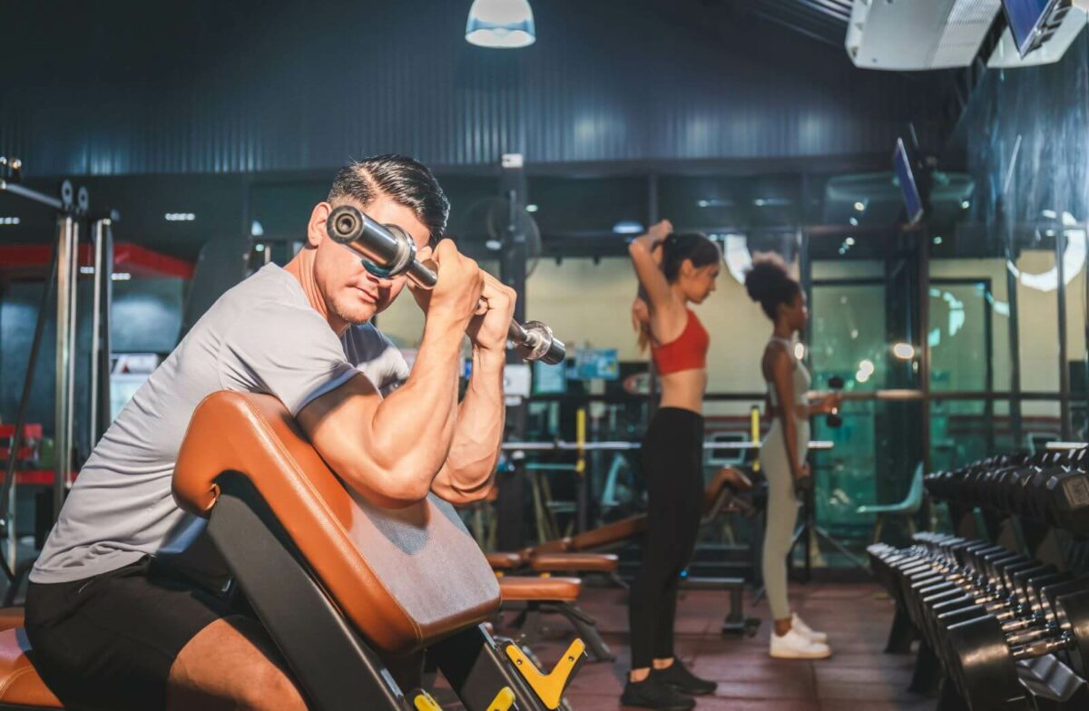 man working out with women also working out in the background